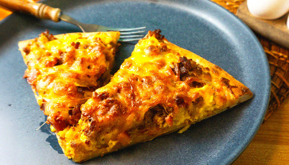 slices of breakfast pizza on plate with fork