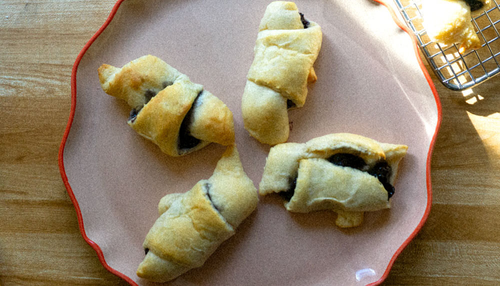 blueberry croissant on white plate.