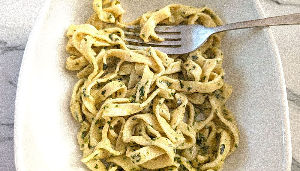home made pasta in a white bowl with a fork.