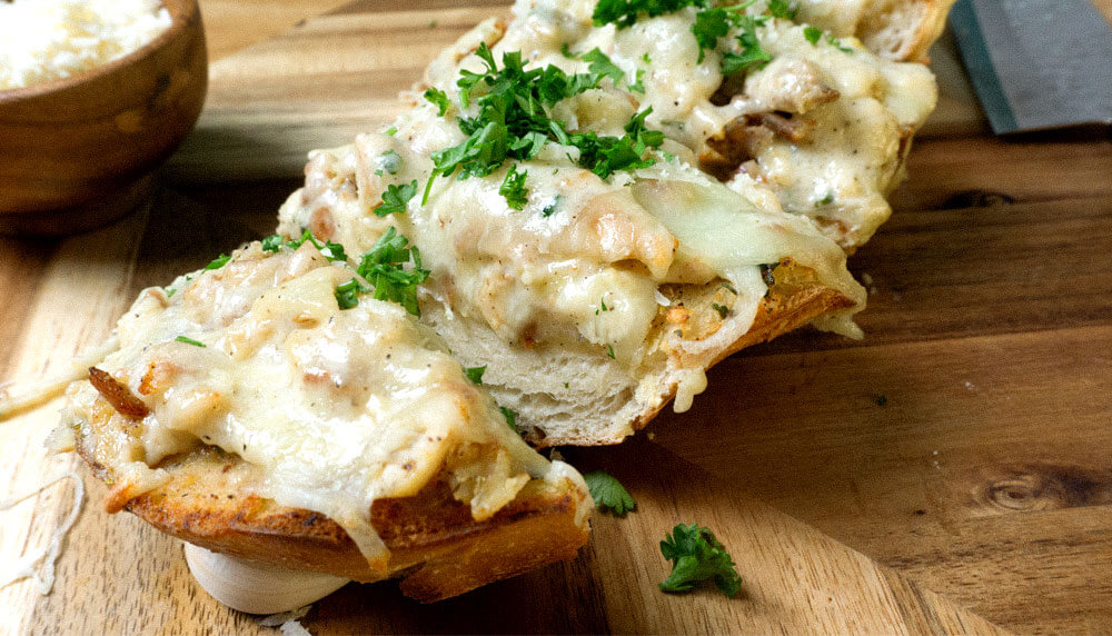 Alfredo Bread with chicken on a wooden cutting board