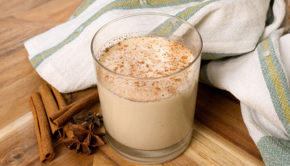 Horchata drink with cinnamon sticks and chinese star anise with napkin in wooden cutting board
