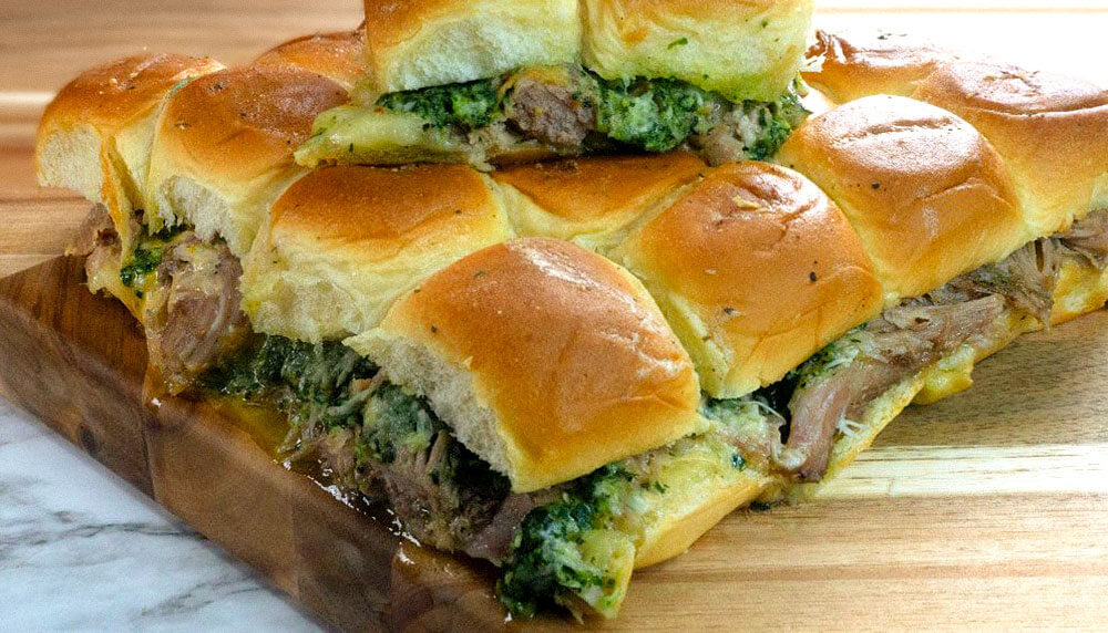 Petso Pork Sliders on buns with a wooden board on marble counter top