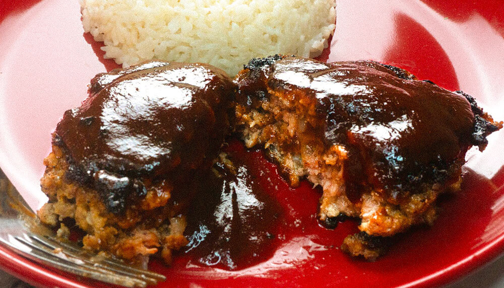 Asian hamberg steak on red plate with rice.